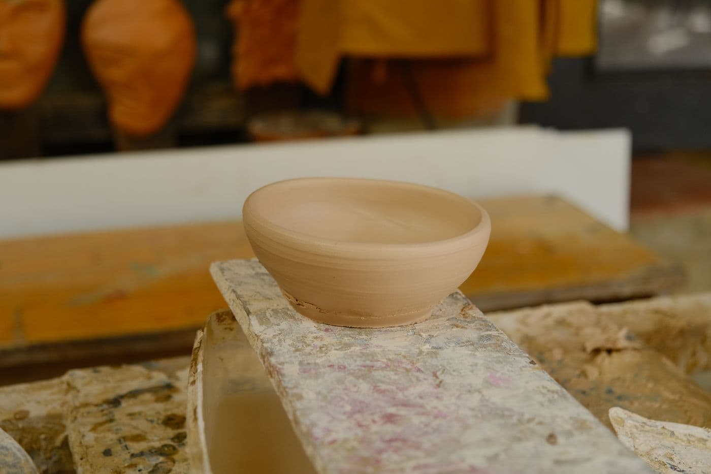 Handmade clay pottery bowl on a workshop table