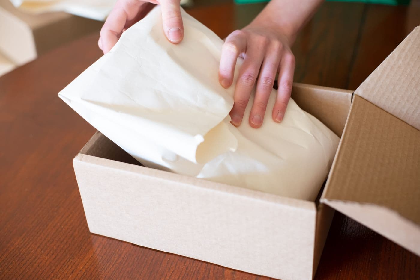Person packing an order into a cardboard box