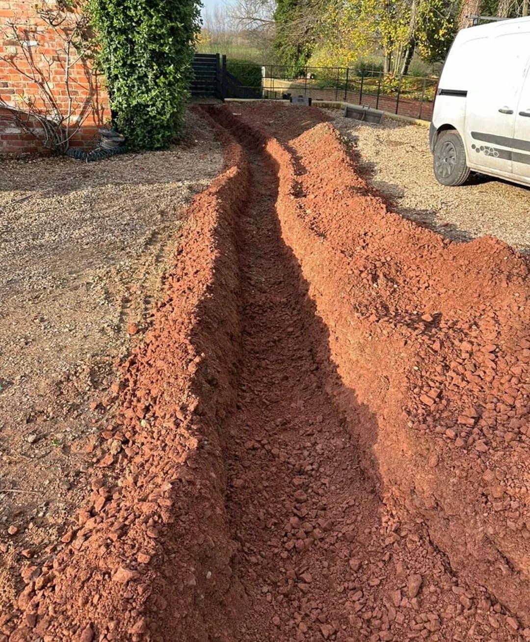 Excavated pipework trench beside a property during an Ekoflow installation