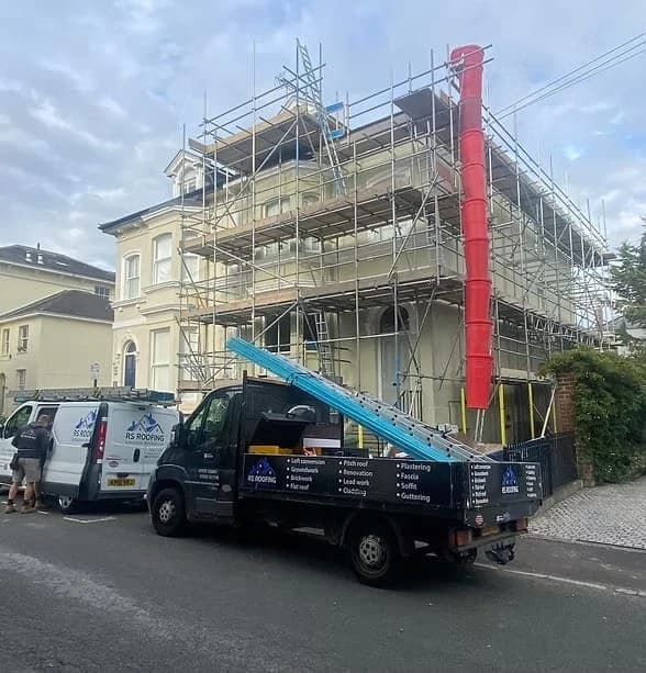 Scaffolded project with R.S Roofing vehicles