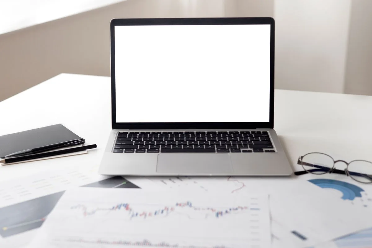 Laptop and business documents arranged on a desk
