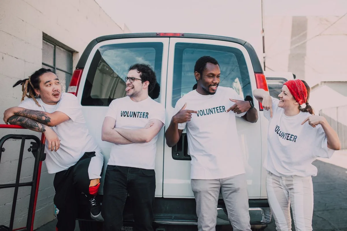 Four volunteers standing together beside a van